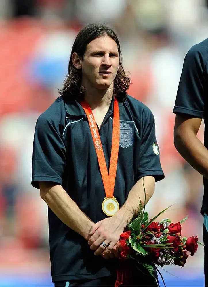 Messi wearing the Beijing 2008 Olympic gold medal, holding red roses