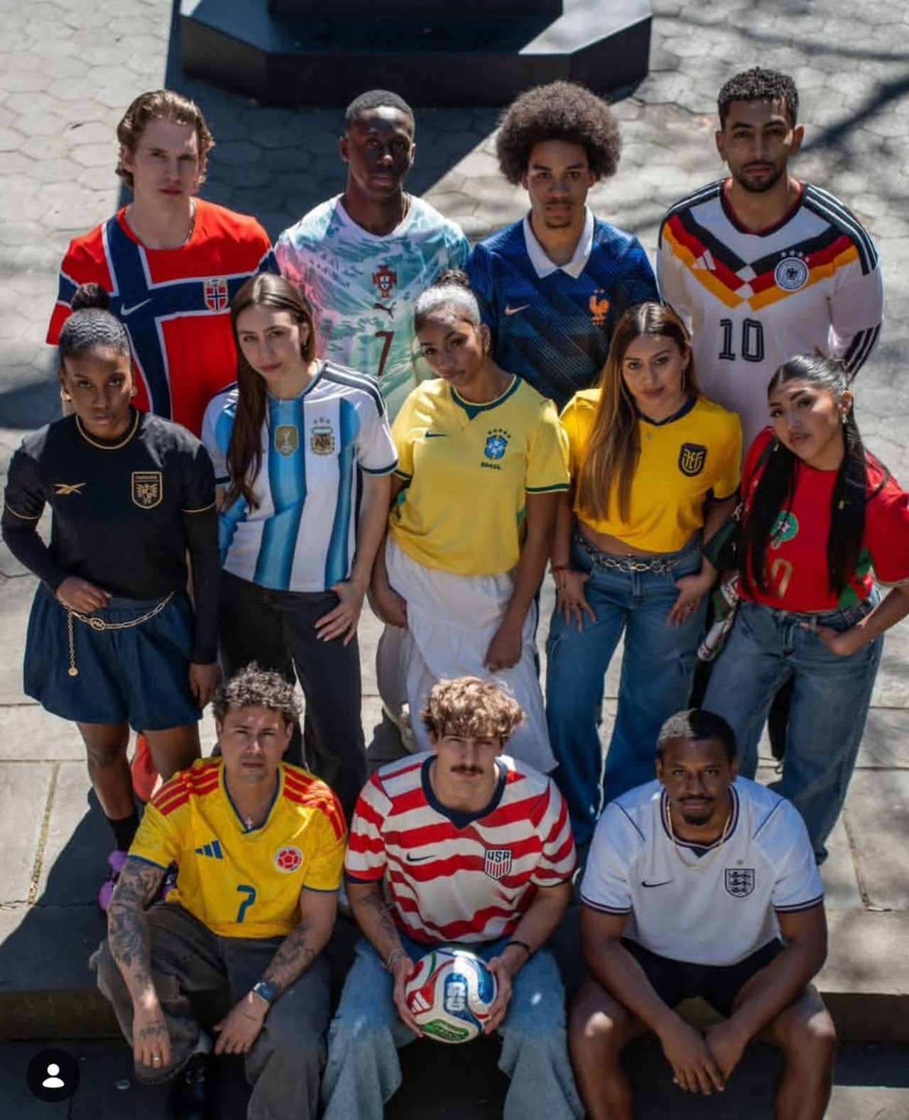 A group of supporters on stone steps wearing national team shirts