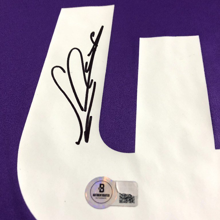Close-up of a hand-signed shirt number beside a Beckett authentication hologram